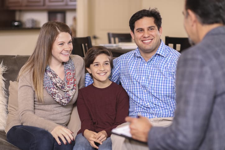 Multi-ethnic family at home with mental health professional